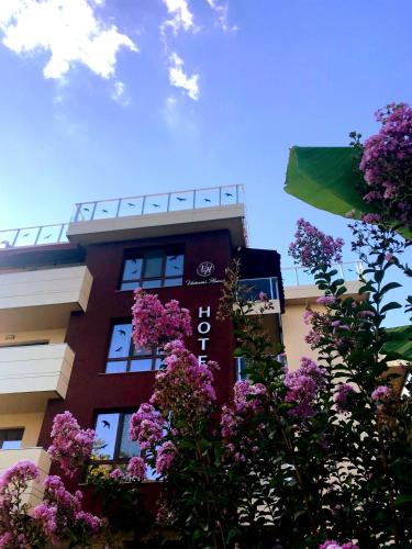 a tall building with purple flowers in front of it at Victoriya's House in Hisarya