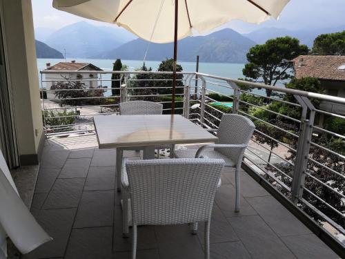 a table and chairs on a balcony with an umbrella at Appartamento Goen in Pisogne