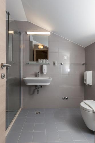 a bathroom with a sink and a toilet at Hotel Vimbula - Komolac in Mokošica