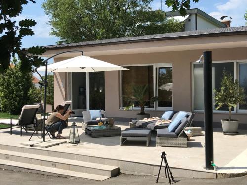 a woman sitting under an umbrella on a patio at Apartments Bego Spa & Wellness in Crikvenica