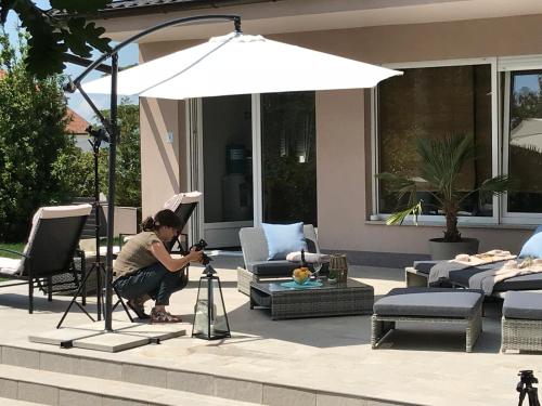 a woman taking a picture under an umbrella at Apartments Bego Spa & Wellness in Crikvenica