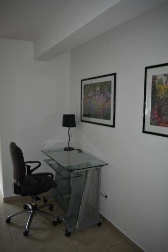 an office with a glass desk and a chair at My Home - Ferienwohnung in Lüdinghausen
