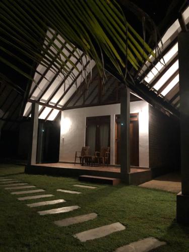 a room with a table and chairs in a building at Riva del Sole Guest House in Arugam Bay
