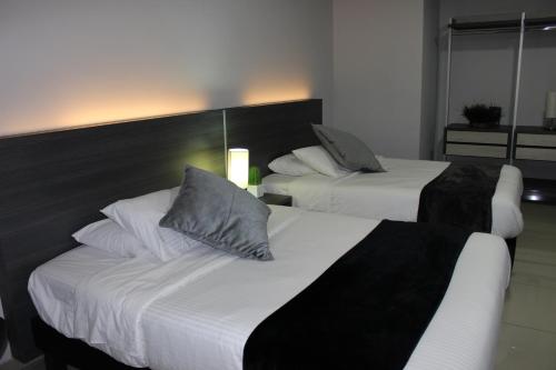 a hotel room with two beds and a couch at Hotel Doral Inn in Ibagué