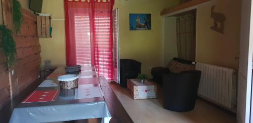 Cette chambre dispose d'une table en bois et de fenêtres rouges. dans l'établissement calsimunot, à Matemale