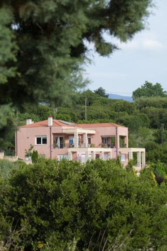 a pink house sitting on top of a hill at Villa Neraida in Neráïdha
