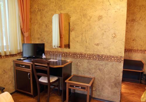 a room with a desk with a television and a mirror at Guesthouse Petra in Veliko Tŭrnovo
