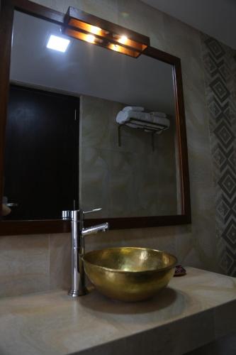 a bathroom sink with a large mirror and a gold bowl at Sabila Boutique Hotel in Kathmandu
