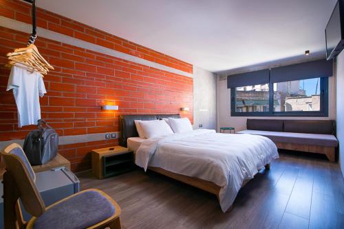 a bedroom with a bed and a brick wall at Urban Donkey in Thessaloniki