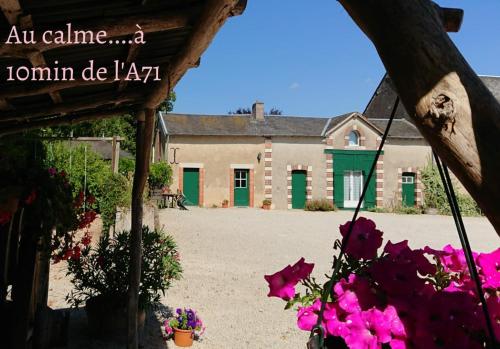 an external view of a house with pink flowers at domaine d'en Haut in Lochy