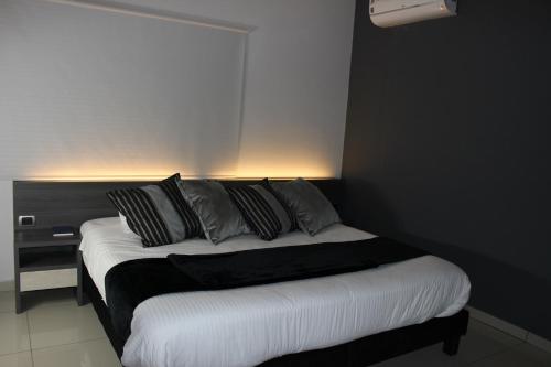 a bedroom with a bed with black and white pillows at Hotel Doral Inn in Ibagué