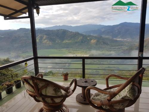 a room with two chairs and a view of mountains at Rinconcito Verde in Ujarrás