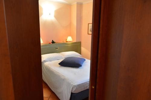 a bedroom with a bed with a blue pillow on it at Residence Del Messaggero in Rovereto