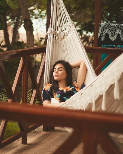a woman is sitting in a hammock at Casa Suiça Brasileira in Jericoacoara