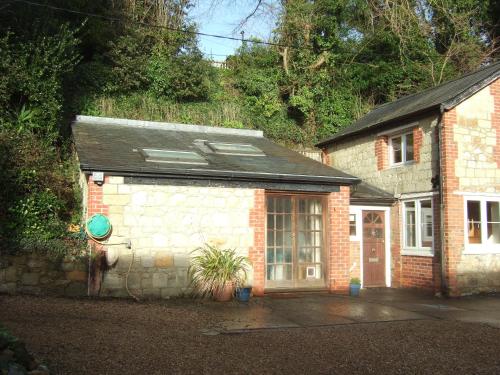 a small brick house with a garage in front at Woodcliffe Sea-view Apts in Ventnor