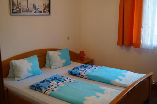 two twin beds in a bedroom with blue pillows at Ferienwohnungen Dzido in Hermagor