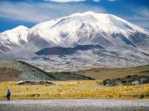 a man standing in front of a snow covered mountain at Hostal Sisabel in Tinogasta