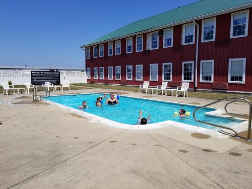 a group of people in a swimming pool next to a building at CountrySide Inn in Nappanee
