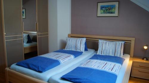 a bedroom with two beds with blue pillows at Ferienwohnungen Dzido in Hermagor