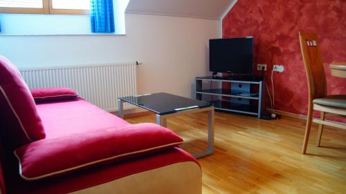 a living room with a couch and a tv at Ferienwohnungen Dzido in Hermagor