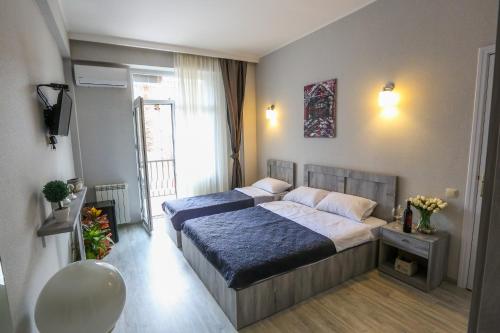a bedroom with two beds and a window at Vortex - City Center in Tbilisi City