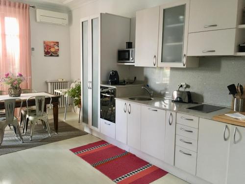 cocina con armarios blancos y mesa de comedor en Apartamento en el centro de Bilbao en Bilbao