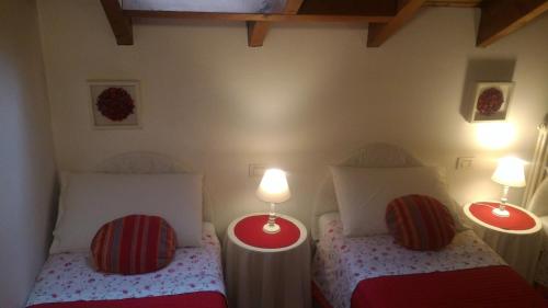 two beds in a small room with two lamps at B&B LE MAGNOLIE in Gallarate