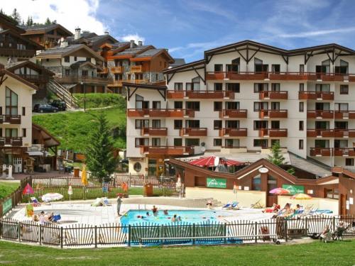 une grande piscine en face d'un grand bâtiment dans l'établissement Appartement La Tania 2 pièces garage dans chalet pied pistes, à La Tania