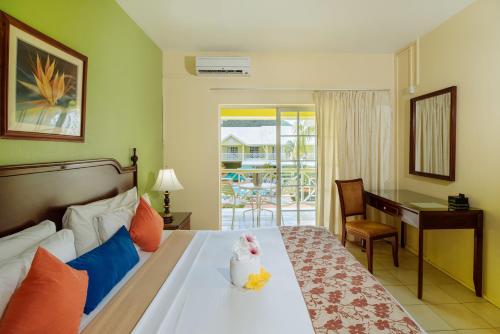 a hotel room with a bed with a desk and a desk at Bay Gardens Hotel in Gros Islet