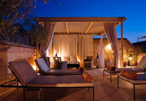 - une terrasse avec des chaises longues et un kiosque la nuit dans l'établissement Riad Tzarra, à Marrakech