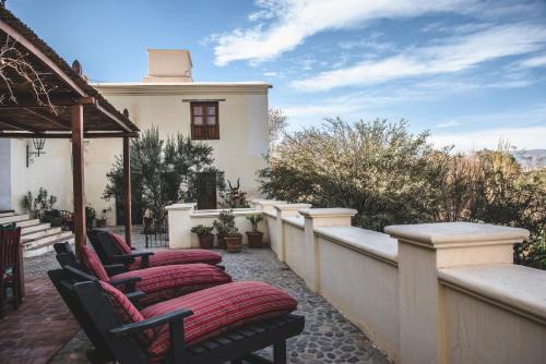 - une rangée de chaises sur une terrasse avec un bâtiment dans l'établissement Casa del Tejedor, à Cachí
