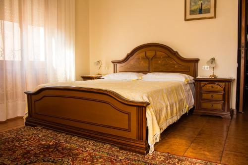 a bedroom with a large wooden bed and a window at Appartamento con terrazza a livello in Quartu SantʼElena