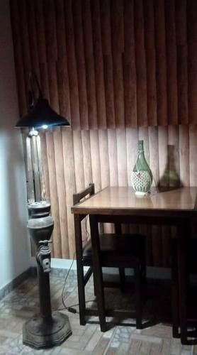 a table with a lamp and a vase on it at Hostal Sisabel in Tinogasta