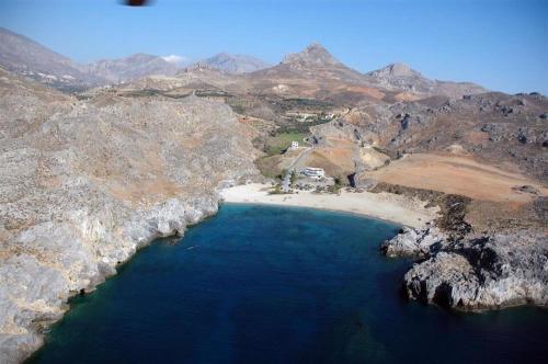 an aerial view of a beach in the middle of a mountain at Schoinaria Bay in Damnoni
