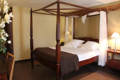 a bedroom with a canopy bed with white pillows at Hospedería de Cuenca in Cuenca