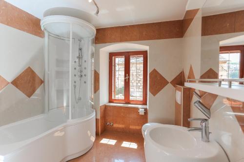 a bathroom with a shower and a sink and a tub at Vila Magdalena in Supetar