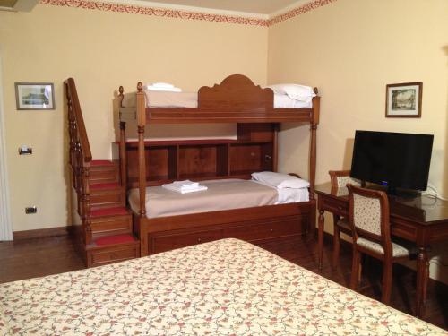 a bedroom with two bunk beds and a desk with a television at La Dependance in Menaggio