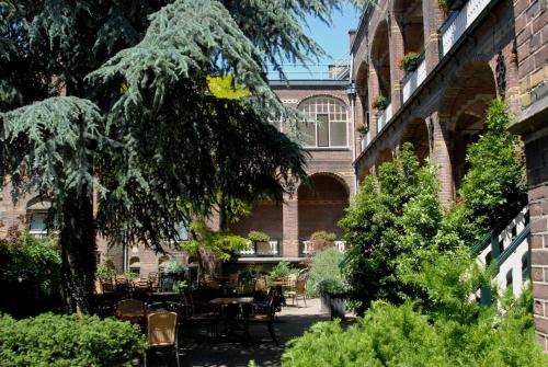 a courtyard with tables and chairs in front of a building at Fletcher Hotel Gilde in Deventer