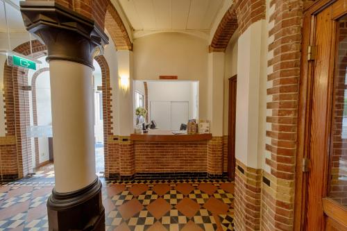 a bathroom with a mirror and a tile floor at Fletcher Hotel Gilde in Deventer