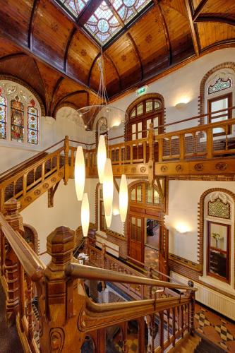 a large building with a wooden ceiling and a chandelier at Fletcher Hotel Gilde in Deventer
