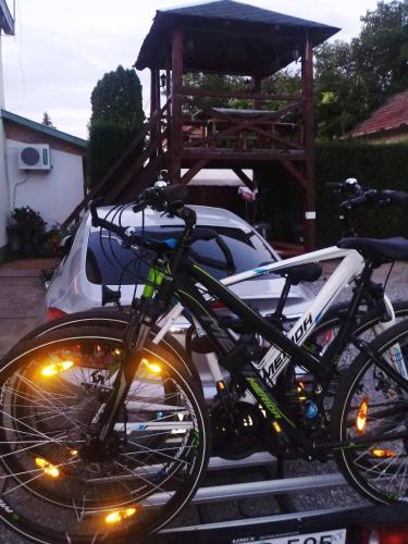 a bike parked next to a car with lights on it at Unicum Vendégház in Abádszalók
