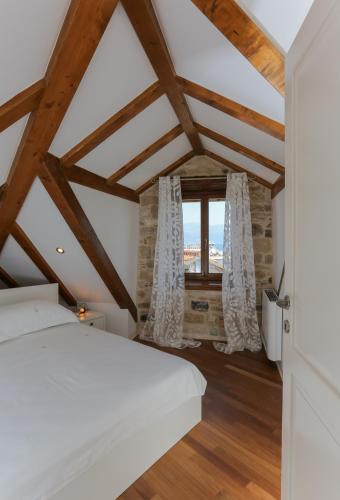 a bedroom with a white bed and a window at Vila Magdalena in Supetar