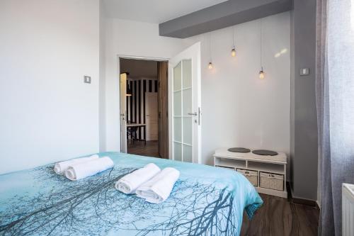 Un dormitorio blanco con dos toallas en una cama. en Apartment Eugen II, en Novi Sad