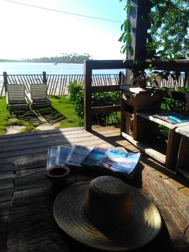 a hat sitting on a table with a view of the ocean at Pousada Pérola do Atlântico in Ilha de Boipeba