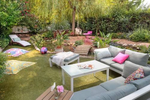 a patio with a couch and a table in a yard at La Villa Des Sens in Lattes