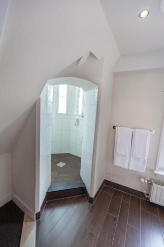 a bathroom with a glass shower in the attic at Fletcher Hotel Gilde in Deventer
