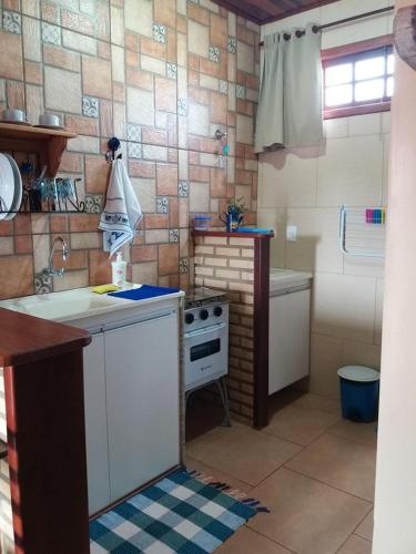 a kitchen with a sink and a stove in it at Estúdio Recanto Dos Anjos in Arraial do Cabo
