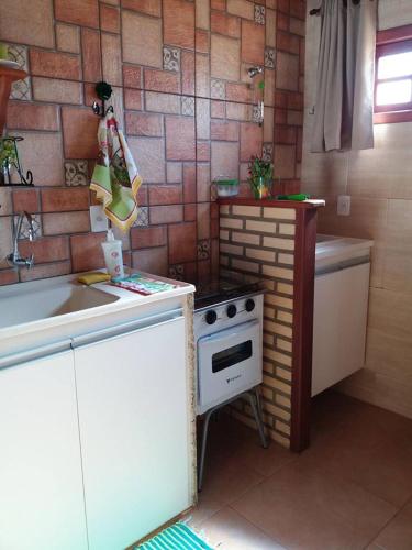a small kitchen with a stove and a sink at Estúdio Recanto Dos Anjos in Arraial do Cabo