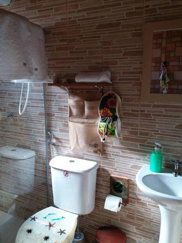 a bathroom with a toilet and a sink at Estúdio Recanto Dos Anjos in Arraial do Cabo