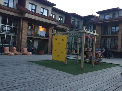 a playground in front of a building with a play structure at Atokvėpis Palangoje in Palanga